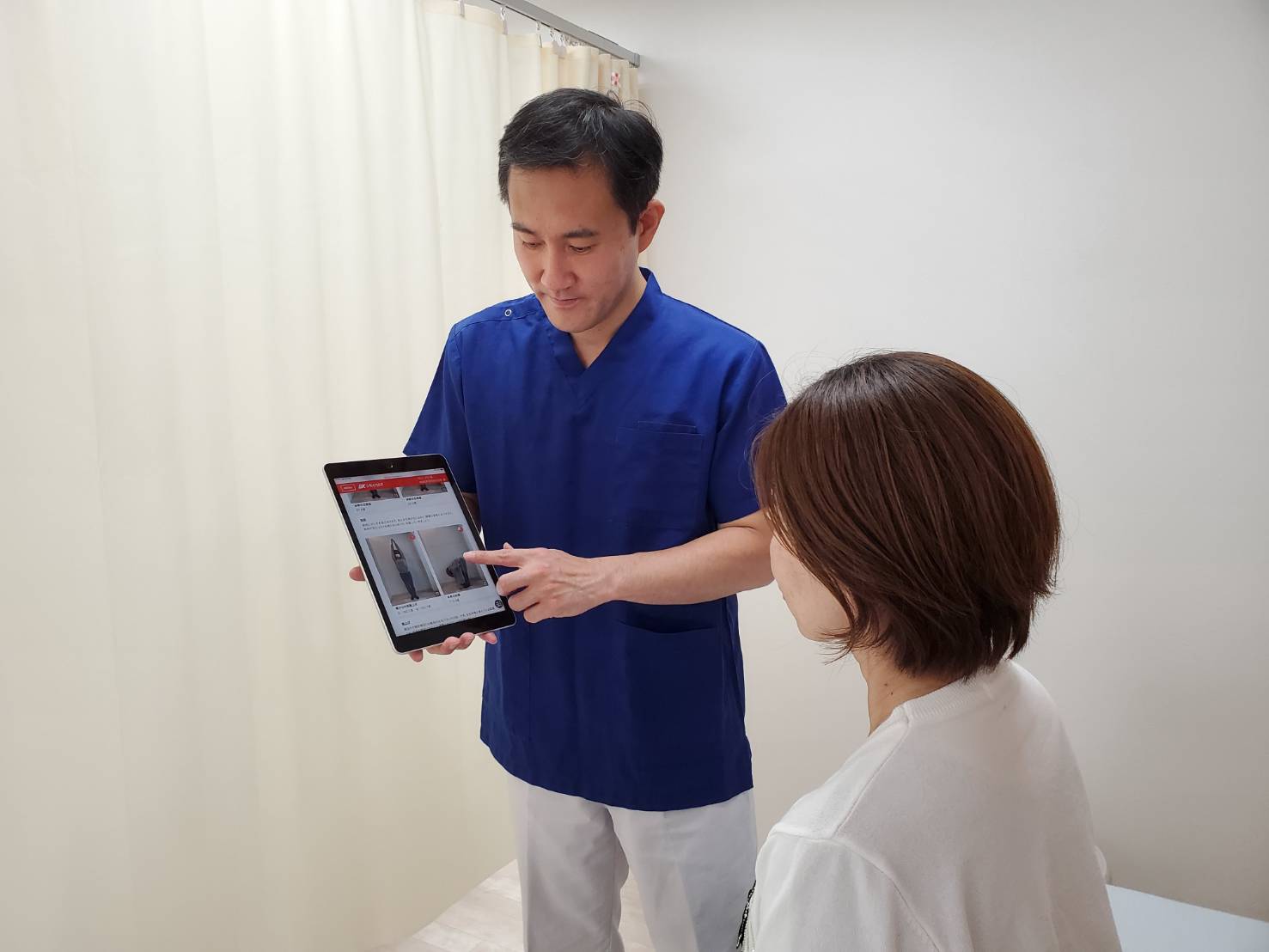 院長がタブレットでAI測定結果を説明している様子